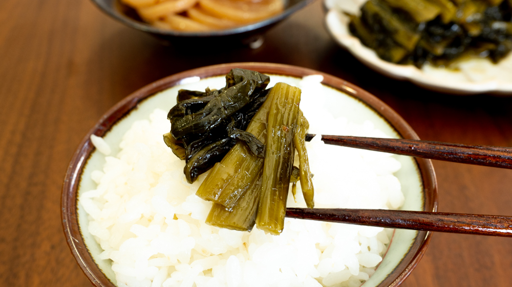 野沢菜の煮たくもじをご飯にのせた美味そうな惣菜画像